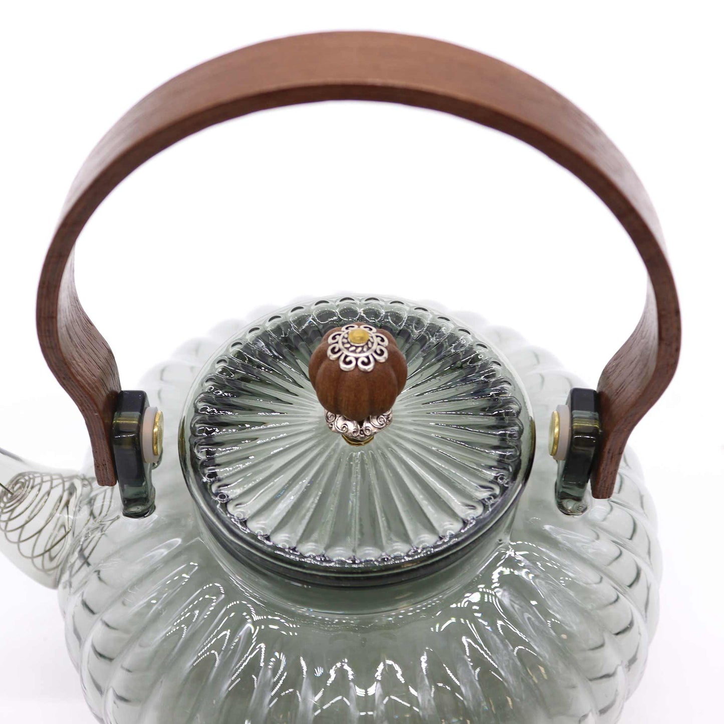 Close-up of ornate pearl-finish lid and arched wooden handle on charcoal ribbed glass teapot