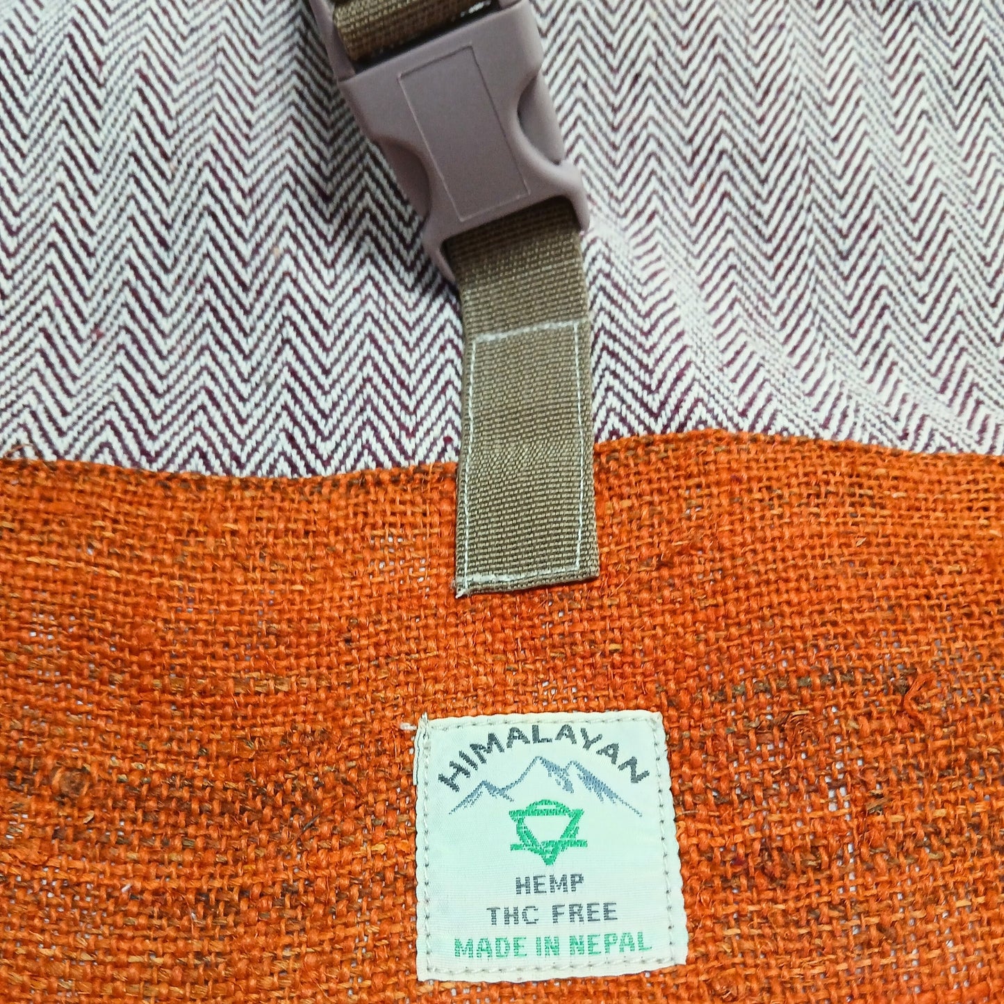 Close-up of label and weave texture on the Sunset Orange hemp trekking backpack