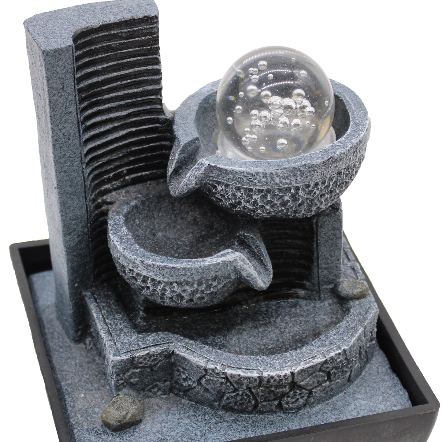 Close-up of resin pouring bowls and clear bubble glass ball on tabletop fountain
