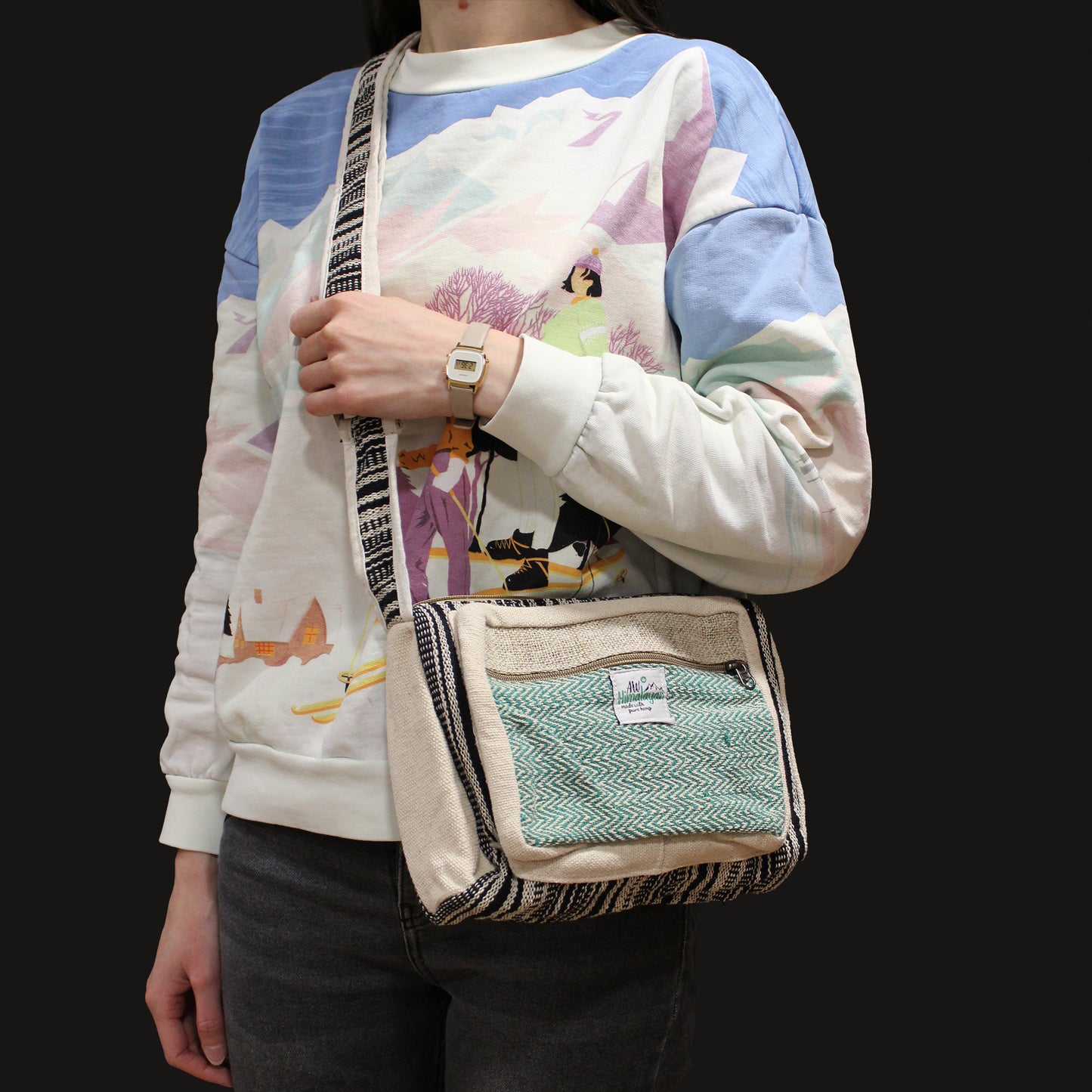 Model wearing eco-friendly hemp messenger bag with green chevron front, sustainable boho accessory for travel and daily wear