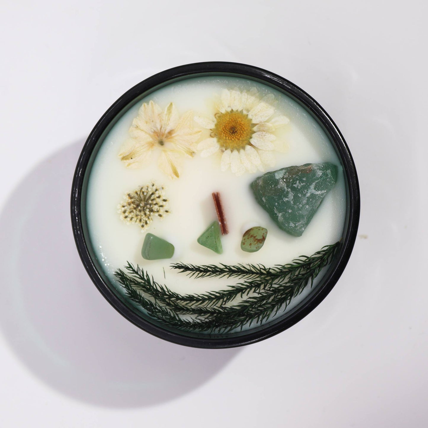 Top view of The Magician Candle showing green soy wax, embedded Jade crystals, and floral details