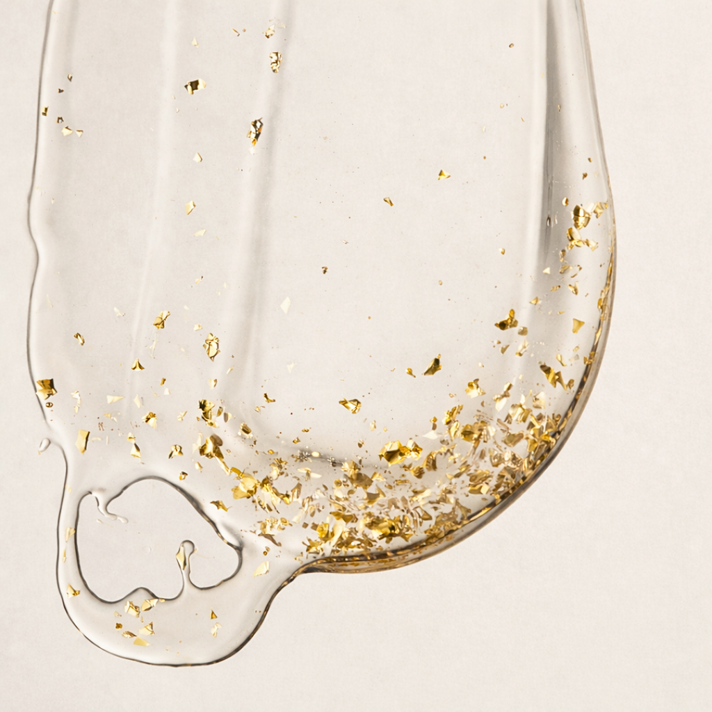 Aurum Lustrum serum with gold flakes on a beige background