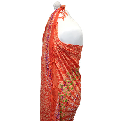 Side view of orange mandala sarong showing intricate green, purple, and red pattern with fringe edges