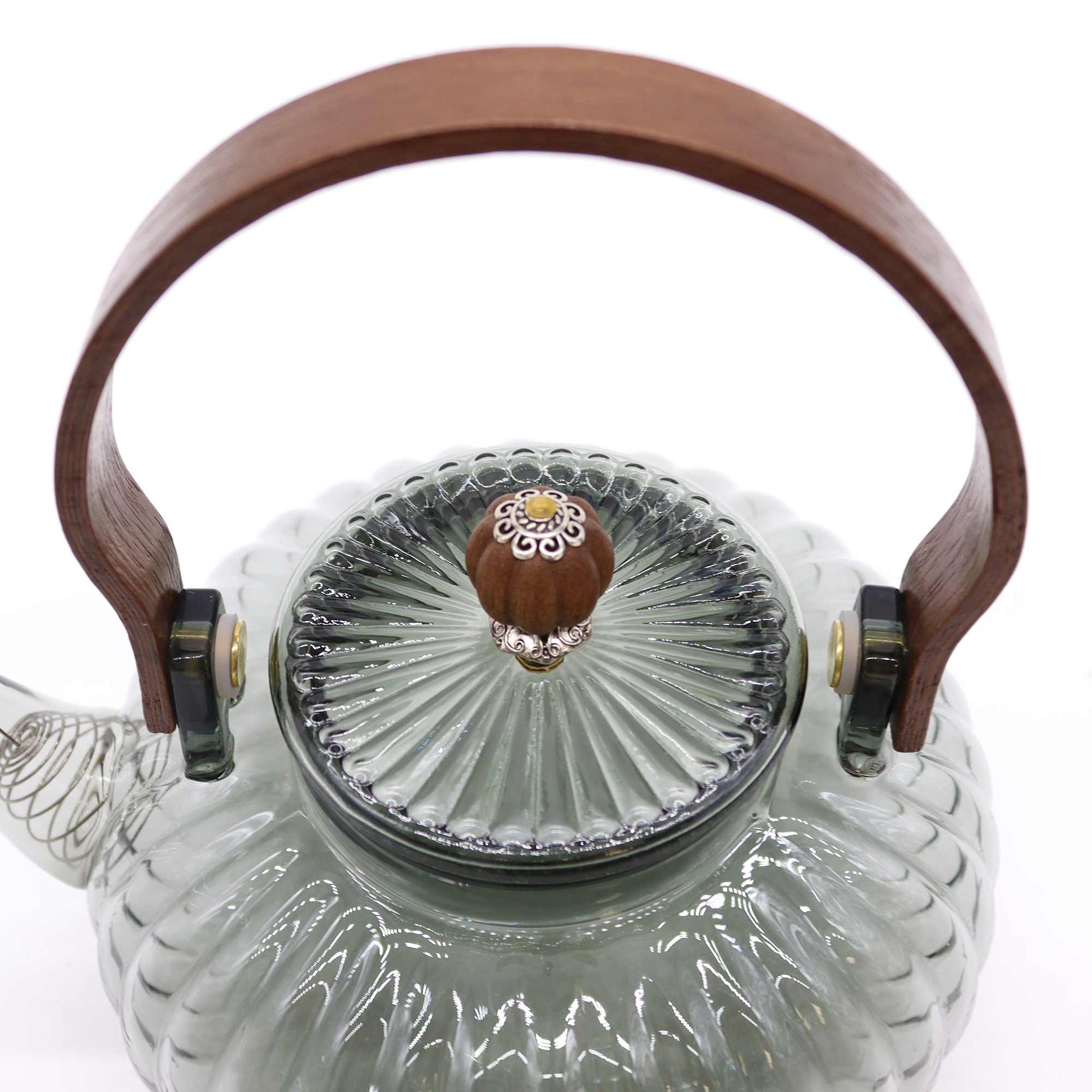 Close-up of ornate pearl-finish lid and arched wooden handle on charcoal ribbed glass teapot