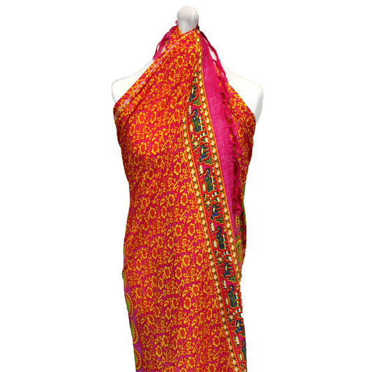 Pink and yellow mandala sarong tied halter-style on mannequin with elephant border trim