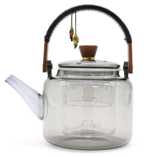 Side view of charcoal-toned glass teapot with built-in steamer and wooden knob lid