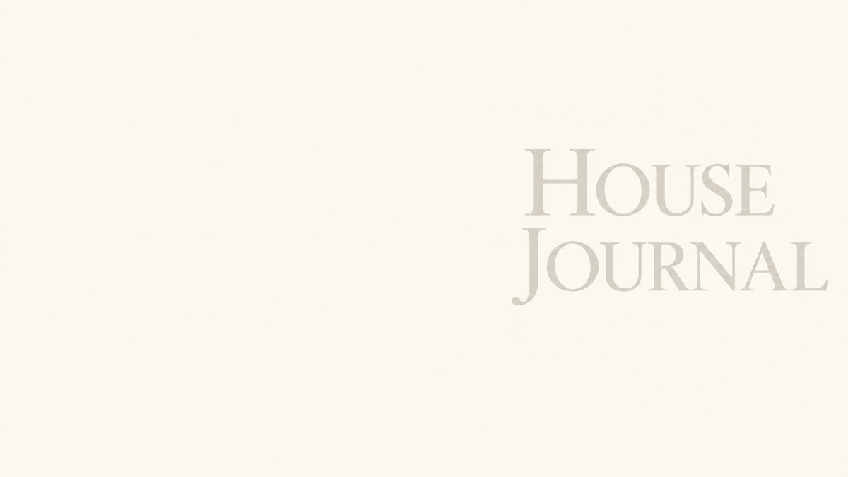 A close-up of a cream-colored paper surface with the words 'HOUSE JOURNAL' printed in a muted gray serif font on the right side.