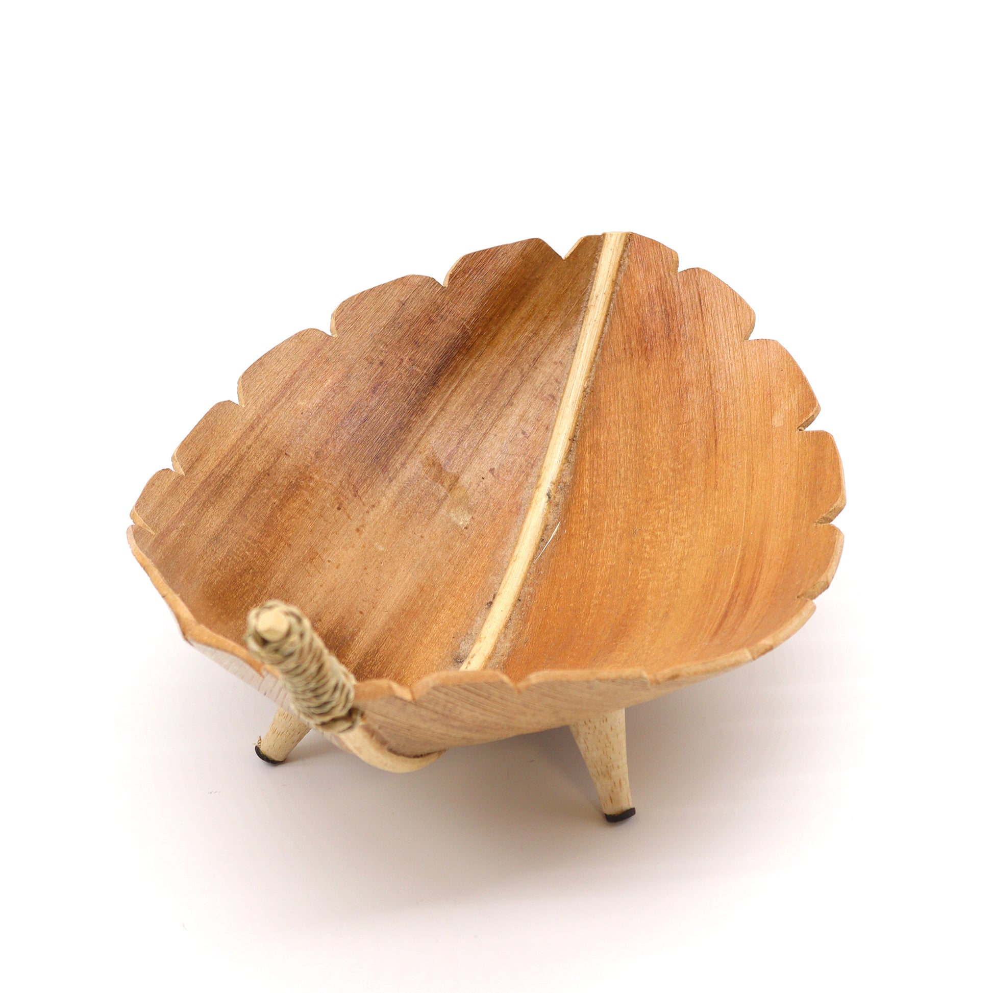 Side view of handcrafted coconut leaf bowl showing natural curve and earthy finish, ideal for sustainable home decor.