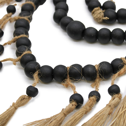 Close-up of wooden bead details on heart-shaped hanging mobile, showcasing artisanal texture and natural materials.