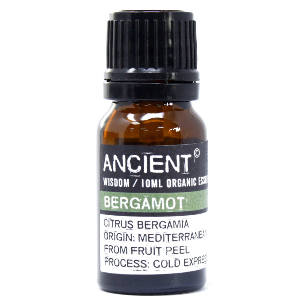 Close-up of a 10ml amber bottle labeled “Ancient Wisdom Organic Bergamot Essential Oil,” showing detailed text about Mediterranean origin and cold-pressed extraction from fruit peel.