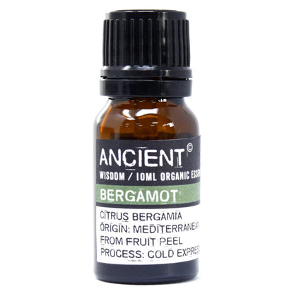 Close-up of a 10ml amber bottle labeled “Ancient Wisdom Organic Bergamot Essential Oil,” showing detailed text about Mediterranean origin and cold-pressed extraction from fruit peel.