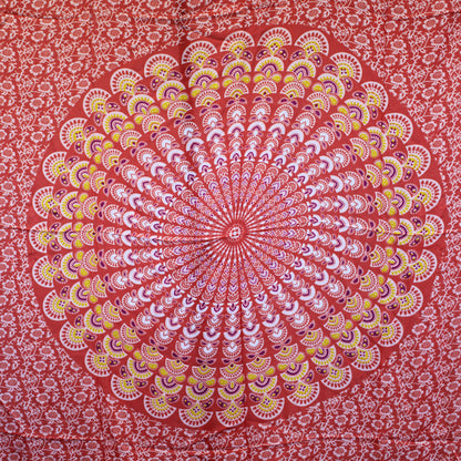 Laid flat sarong displaying circular peacock-style mandala in vibrant orange, pink, and green tones