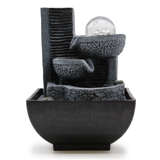 Black stone-look tabletop water feature with two pouring bowls and glass bubble ball