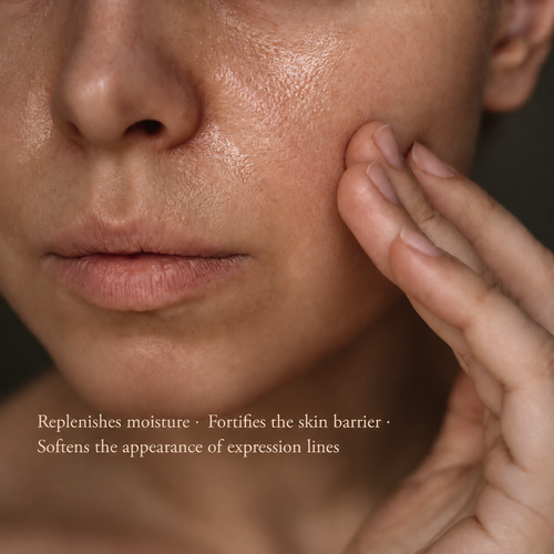 Close-up of a person's face and hand touching their cheek, with text at the bottom reading 'Replenishes moisture • Fortifies the skin barrier • Softens the appearance of expression lines'.