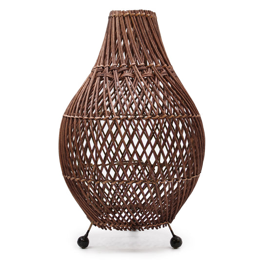 Handcrafted dark brown rattan table lamp with curved teardrop design and rounded metal feet on white background.