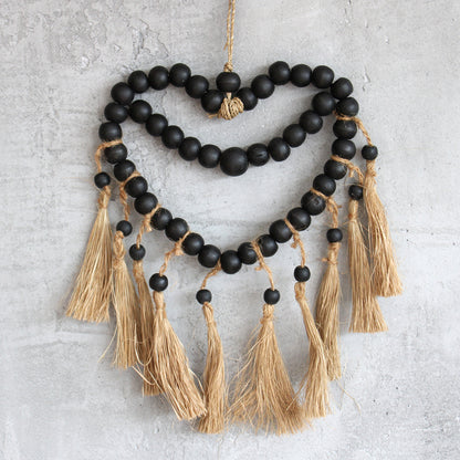 Beaded heart hanging decor styled on a neutral wall, adding rustic charm to mindful, earth-toned interiors.