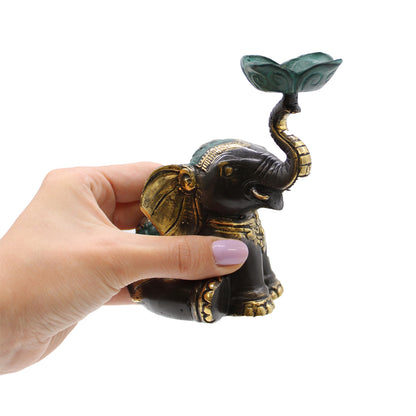 Hand holding brass elephant candle holder to show size and scale, ideal for gifting or altar use