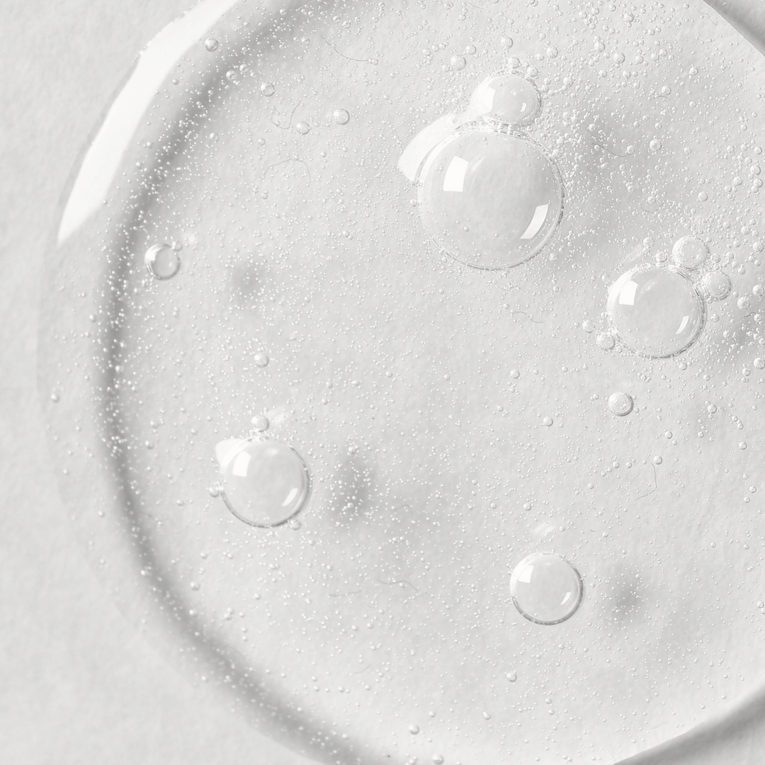 Close-up of clear liquid with bubbles on a light gray background