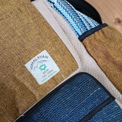 Close-up of handmade hemp backpack label showing turmeric and teal woven texture, made in Nepal with THC-free sustainable materials