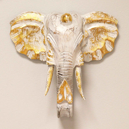 Lifestyle photo of gold and whitewash elephant wall hanging in bohemian decor setting