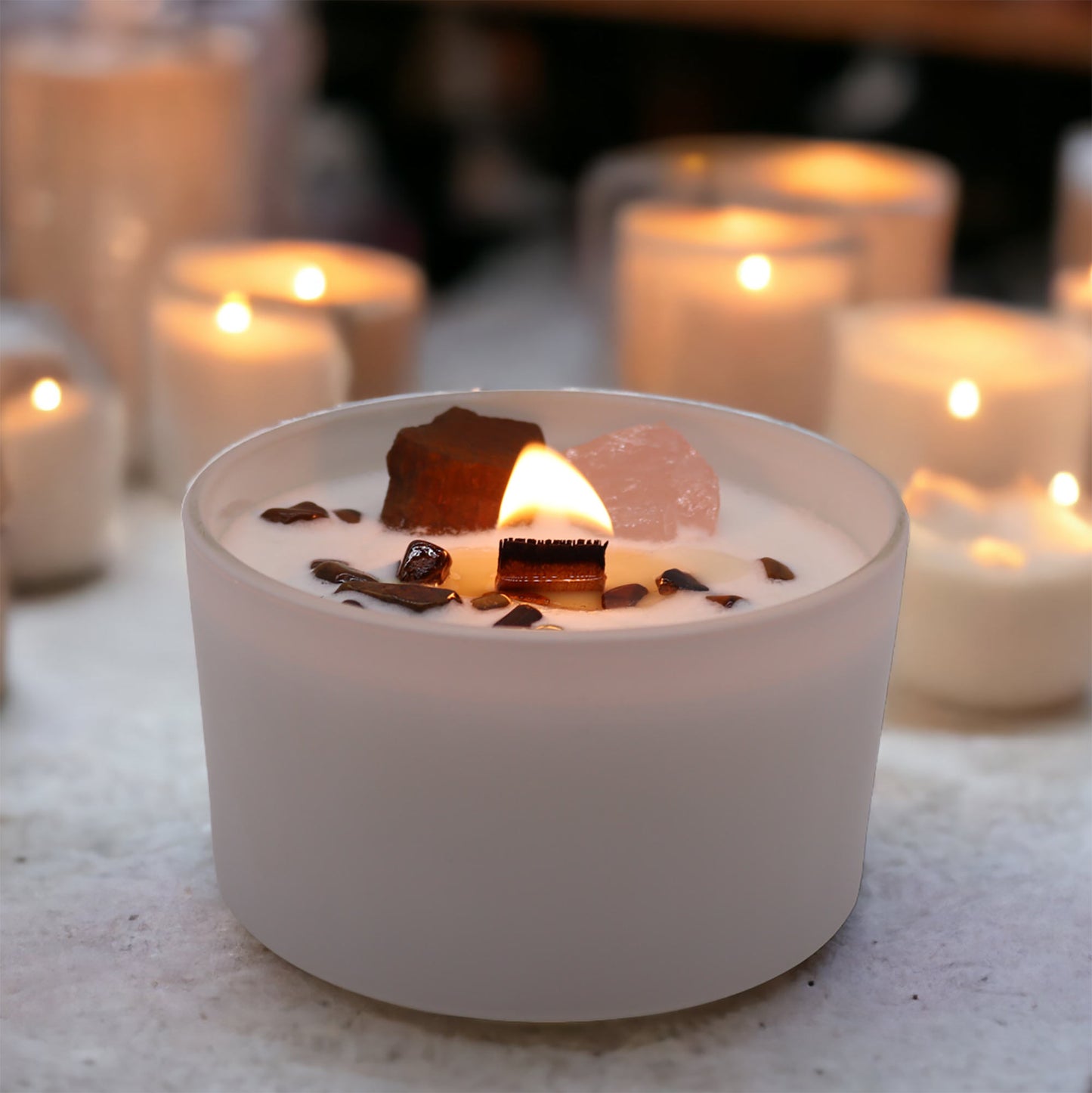 Close-up of Tiger Eye and Rose Quartz crystals inside Sacral Chakra Candle for emotional balance