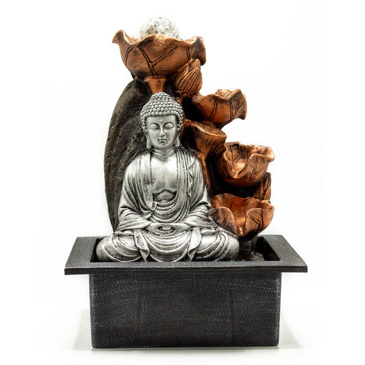 Tabletop water fountain with silver Buddha and cascading bronze lotus flowers, ideal for meditation and relaxation spaces.