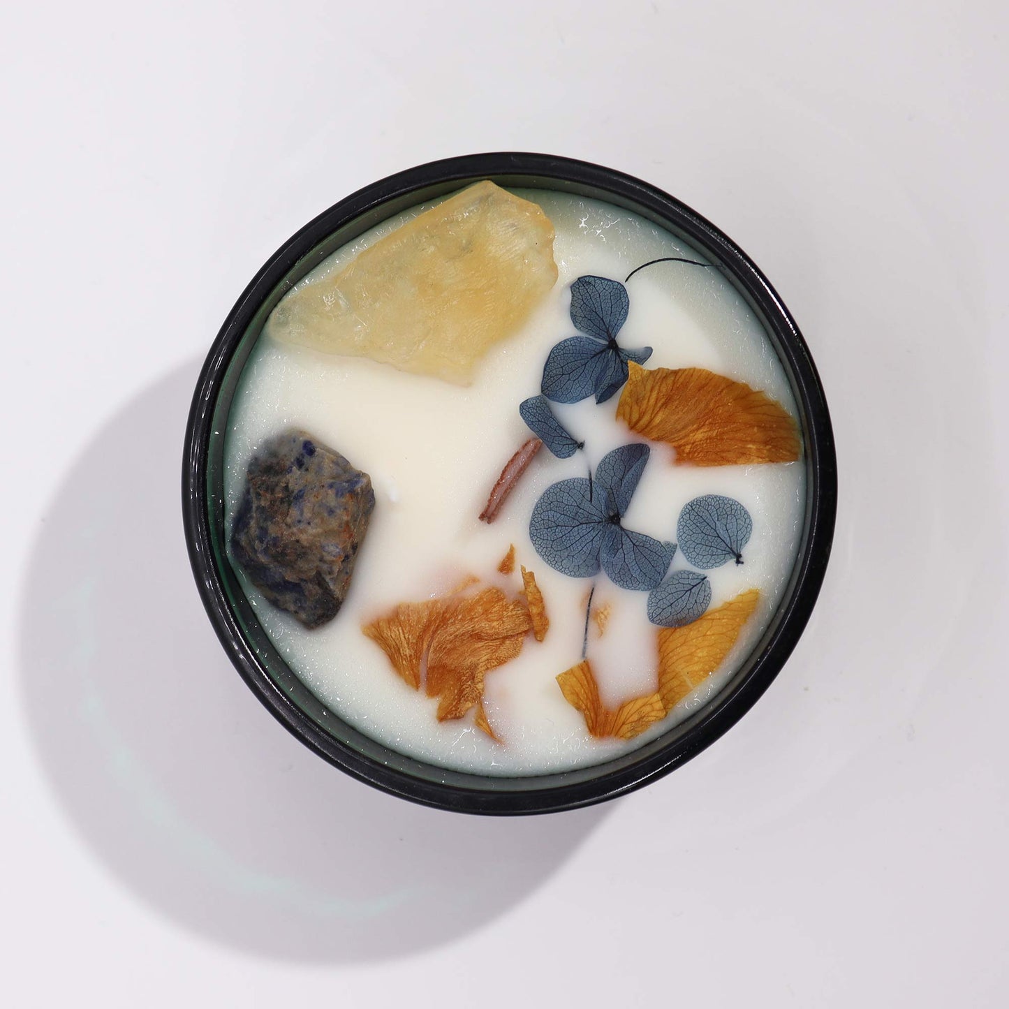 Top view of The Sun Candle showing vibrant soy wax, dried flowers, and citrine crystals